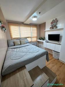 a bedroom with a large bed and a television at Relax & feel cozy here @ Seawind in Davao City +4 photos