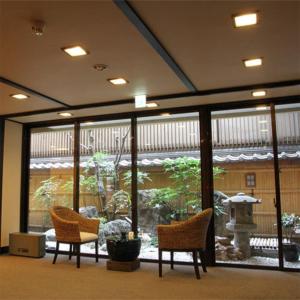 a lobby with two chairs and a large glass window at Kamogawakan in Kyoto