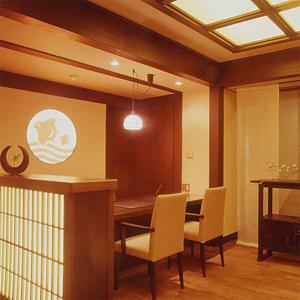 a dining room with a table and chairs at Kamogawakan in Kyoto