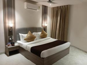 a bedroom with a large bed with two pillows at BK Castles Hotel in Jabalpur