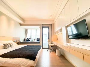 寶安的住宿－Rho Hotel柔居酒店公寓，一间卧室配有一张大床和一台平面电视