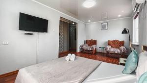 Schlafzimmer mit einem Bett und einem Flachbild-TV in der Unterkunft 1-комнатная Премиум апартаменты в центре города, Сакура уютная люкс in Petropawlowsk