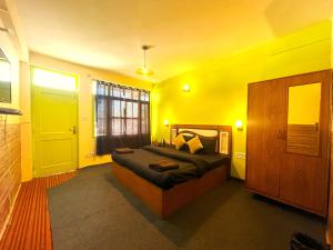 a bedroom with a bed in a yellow room at Trippy Turtle Hostel in Manāli