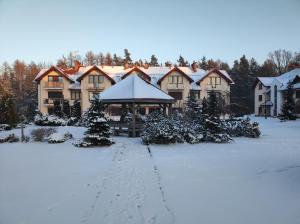 a large house with a snow covered yard at Ustronny Zakątek in Ustroń
