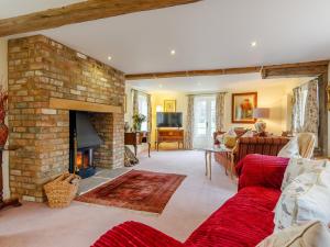 uma sala de estar com um sofá vermelho e uma lareira de tijolos em 3 Bed in Frampton on Severn 80634 em Frampton on Severn
