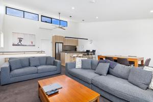 a living room with two couches and a table at Stockyards 3 - Jindabyne Luxury Townhouse in Jindabyne +16 photos