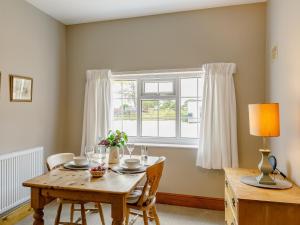 comedor con mesa de madera y ventana en 1 bed property in Easingwold 84002, en Crayke