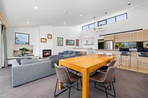 a living room with a wooden table and a couch at Stockyards 3 - Jindabyne Luxury Townhouse in Jindabyne