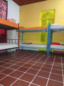 a room with two bunk beds and a tiled floor at Karim Hostel in Guatemala