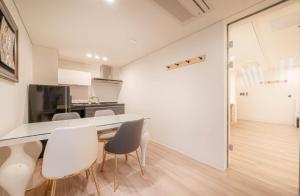 a kitchen and dining room with a table and chairs at H Moment Hotel Yeonsan in Busan