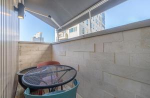 a table and chairs on a balcony with a tennis racket at H Moment Hotel Yeonsan in Busan