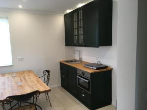 a kitchen with black cabinets and a wooden table at Appartement in Odenthal, ruhig und doch zentral in Odenthal
