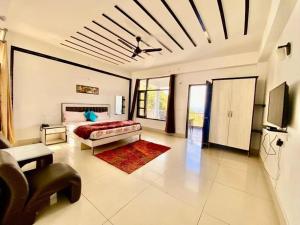 een slaapkamer met een bed en een tv in een kamer bij The Terrace Retreat by StayVues in Kasauli