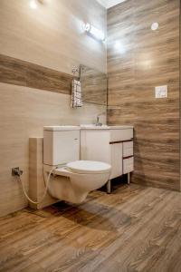 een badkamer met een toilet, een wastafel en een spiegel bij The Terrace Retreat by StayVues in Kasauli