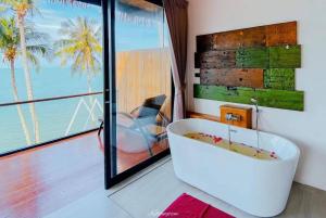 e bagno con vasca e vista sull'oceano. di Aokhanom Resort a Khanom