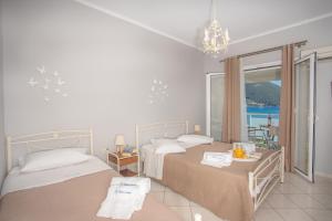 a bedroom with two beds and a view of the ocean at Romanza Studios in Vasiliki