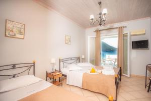 a hotel room with two beds and a balcony at Romanza Studios in Vasiliki