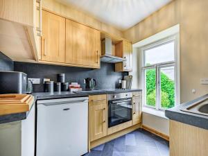 a kitchen with wooden cabinets and a window at 2 Bed in Cockermouth 87481 in Cockermouth
