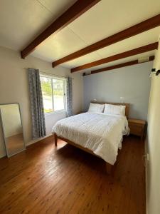 a bedroom with a large bed and a window at By the Bay Beach Shack in Vincentia