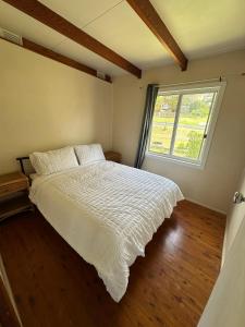 A bed or beds in a room at By the Bay Beach Shack