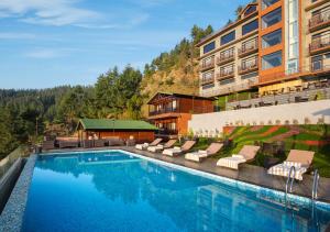 uma piscina com espreguiçadeiras e um hotel em jüSTa Cliffend Resort & Spa, Mashobra em Kīar