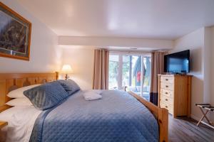 a bedroom with a bed with a television and a dresser at Tahoe Waterfront Condo with Boat Dock in South Lake Tahoe