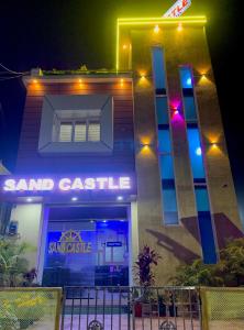 a building with a sign that readssand castle at night at SAND CASTLE in Konārka