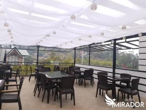 a patio with tables and chairs under a white tent at Hotel Mirador in Baguio