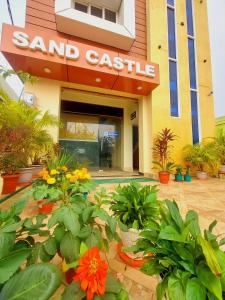 un castillo con flores delante de él en SAND CASTLE, en Konark