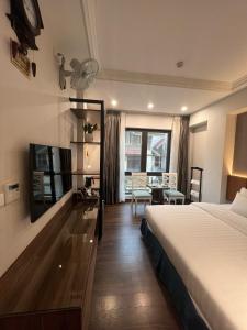 ハノイにあるA25 Hotel - 187 Trung Kínhのベッド、デスク、テーブルが備わる客室です。