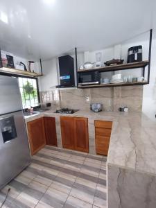 a large kitchen with wooden cabinets and appliances at Villa bonita in Puerto Jiménez