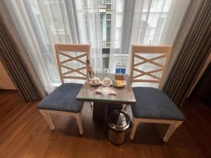 uma mesa de jantar e 2 cadeiras com uma mesa e cadeira em A25 Hotel - 187 Trung Kính em Hanói