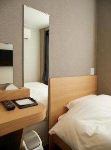 Cette chambre comprend un lit et un bureau avec un miroir. dans l'établissement 心乃宿 Kokoro No Yado-Newly renovated, à Nagoya