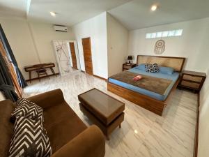 a large bedroom with a bed and a couch at Medewi Secret SurfCamp in Pulukan