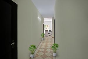 a hallway with potted plants on the floor at OYO Rajvanshi Residency in Gurgaon