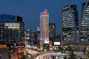 a city skyline with tall buildings at night at Aloft Seoul Myeongdong in Seoul