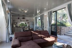 sala de estar con sofá marrón y cocina en Tenuta Bouganville With Garden And Pool - Happy Rentals, en Carpignano Salentino