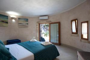 1 dormitorio con 1 cama con manta azul y ventana en Tenuta Bouganville With Garden And Pool - Happy Rentals, en Carpignano Salentino