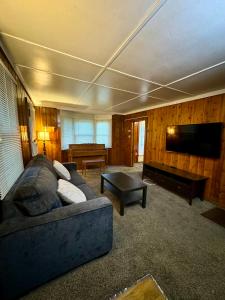 Crest Lodge Historic Mountain Inn في Crestline: غرفة معيشة مع أريكة وتلفزيون بشاشة مسطحة