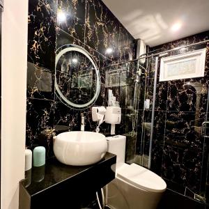 een zwart-witte badkamer met een toilet en een wastafel bij Như Bình Hotel in Ho Chi Minh-stad