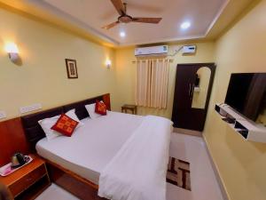 a bedroom with a bed and a flat screen tv at SAND CASTLE in Konārka