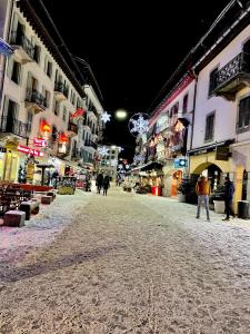 um grupo de pessoas andando por uma rua à noite em Studio Le 4122 - Chamonix centre Clos du Savoy em Chamonix-Mont-Blanc