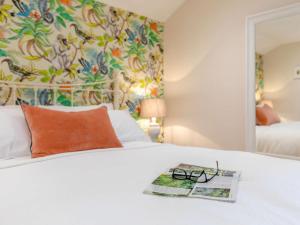 a book and glasses on a bed with a mirror at 1 Bed in Sherborne 83499 in Wincanton