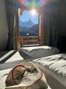 two beds in a room with a view of a mountain at Dolomiti Lodge Villa Gaia in Valle di Cadore