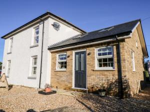 a white brick house with a blue door at Little Osney in Bembridge