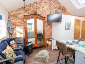 a living room with a brick wall at Little Osney in Bembridge