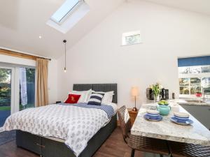 a bedroom with a bed and a table with chairs at Little Osney in Bembridge