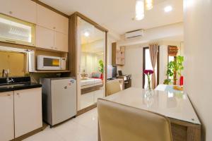 a kitchen with a table with a vase of flowers on it at Tamansari Sudirman Apartment in Jakarta