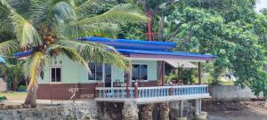 una casa con techo azul y palmera en Chuttong resort en Trat