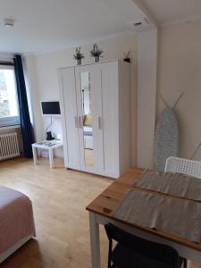 ein Wohnzimmer mit Tisch und ein Schlafzimmer in der Unterkunft Apartment am Bach in Augsburg